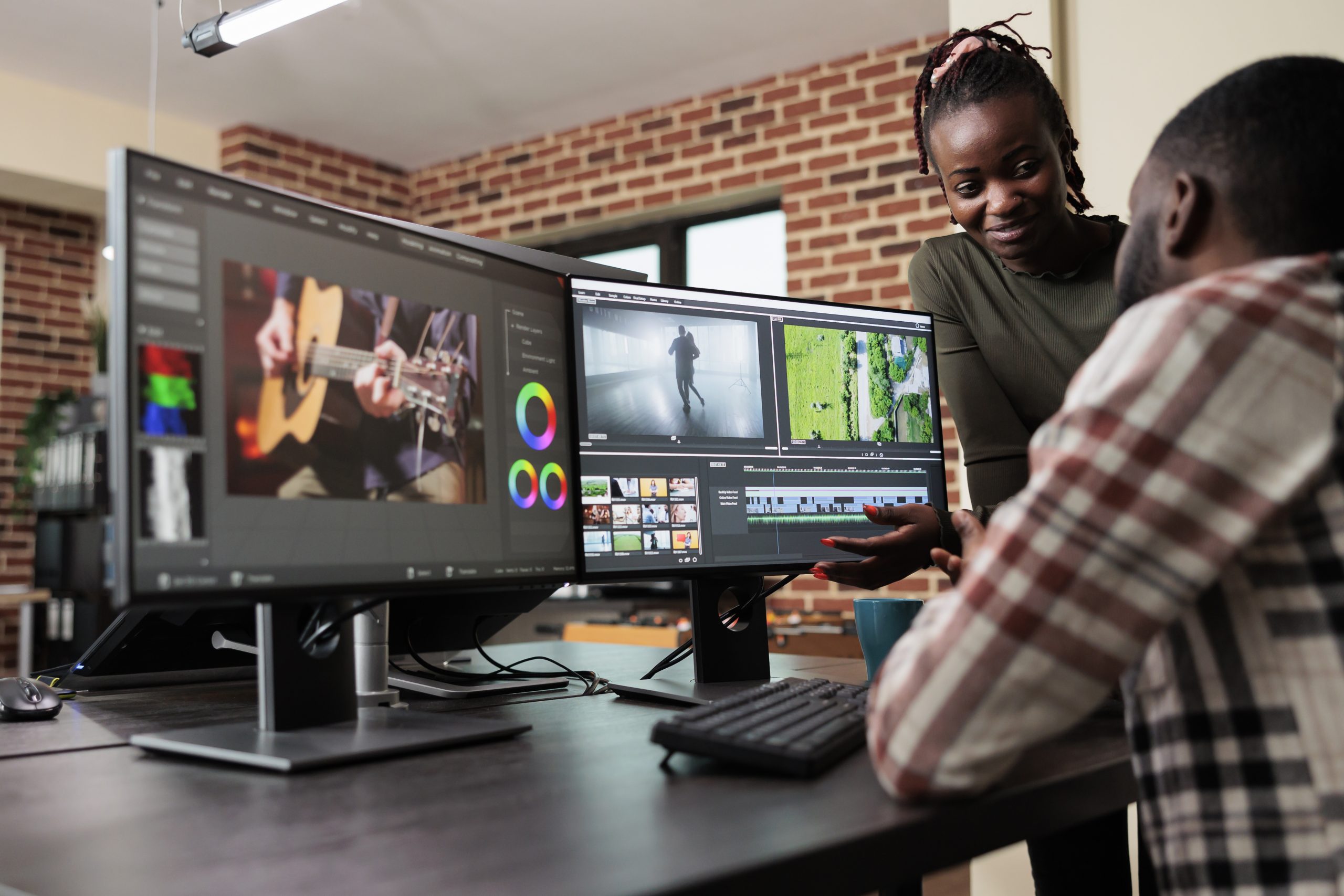 Post production department leader advising colleague to improve colors and frames quality of footage. Creative professional video editors collaborating in order to finish film project upon deadline.